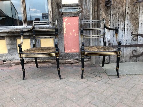 a pair regency ebonised caned chairs
