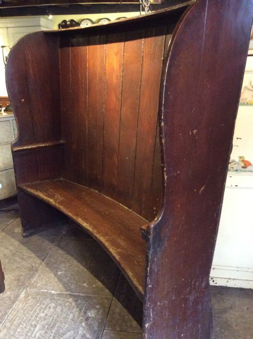 a 19thc curved high back stained pine settle