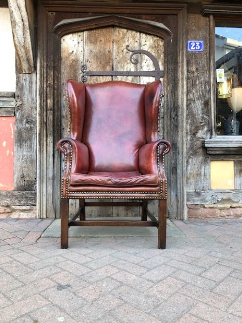a 20th century mahogany framed red leather wing armchair