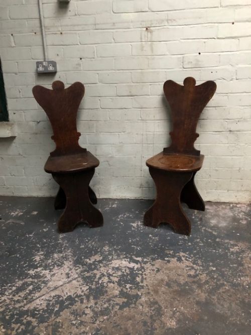a pair of 18th century oak hall chairs